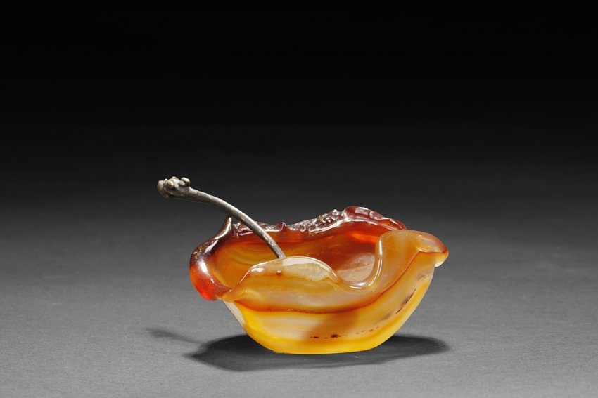 AN AGATE WASHER WITH SPOON: The edge of floriform, surmounted by a swimming goldfish with a Chinese coin, the stone of natural color and formation, with the darker colors on top and lighter colors on bottom, and the spoon handle