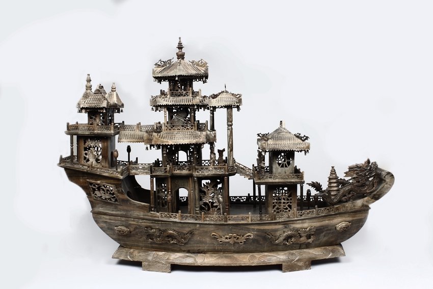 A LARGE WOOD CARVED CHINESE DRAGON BOAT: Finely carved and pierced as large boat with two dragons as prow and the deck surmounted with intricate pagodas with variously shaped Buddhist emblems openwork as windows, the structures linked to eac