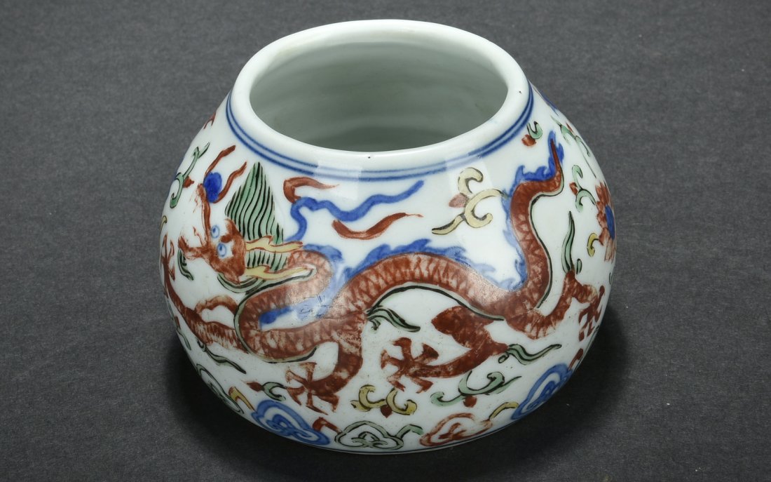 WUCAI 'DRAGON' WASHER: Of domed form, the washer depicts flying dragons chasing flaming spheres amidst scrolling flowers all above scrolling ruyi cloud patterns, the bottom bear six character WANLI mark. H: 2 1/2 in (6.3 cm