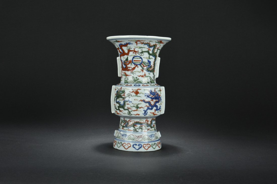 WUCAI FLOWER VASE, GU: Of archaic bronze vessel Gu shape, the vase enameled in Wucai with motif of dragons chasing flaming sphere amidst clouds, bottom bears six character WANLI mark. H: 10 11/16 in (27.2 cm) D: 6 3/16 in (