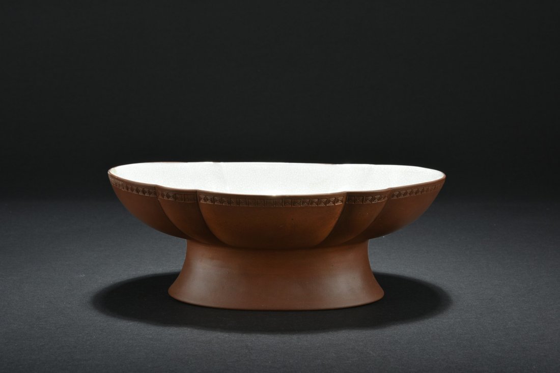 YIXING ZISHA OFFERING BOWL: The large Zisha bowl has floriform rim with key-fret patterns, the interior and bottom glazed in white with crackle patterns, the exterior remain red clay. H: 3 13/16 in (9.6 cm) W: 10 1/8 in (25.7 cm