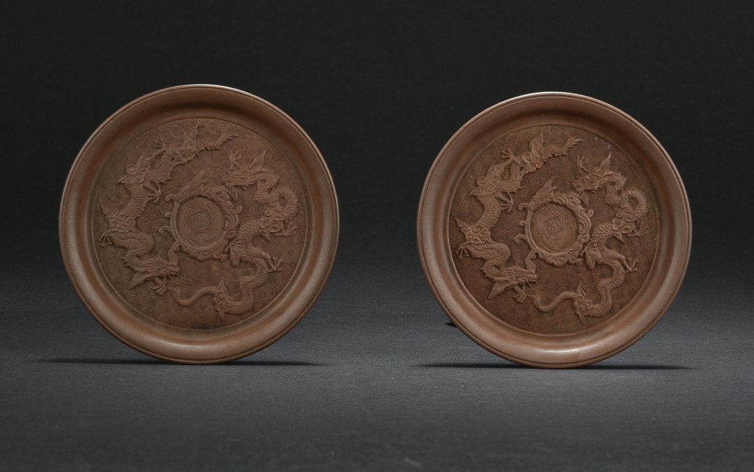 PAIR OF YIXING ZISHA DRAGON SAUCERS: The pair of saucers carved with two four-claw dragons surrounding a flaming sphere, against hui pattern, the center bears four character mark. H: 1/2 in (1.3 cm) D: 4 3/4 in (12 cm)