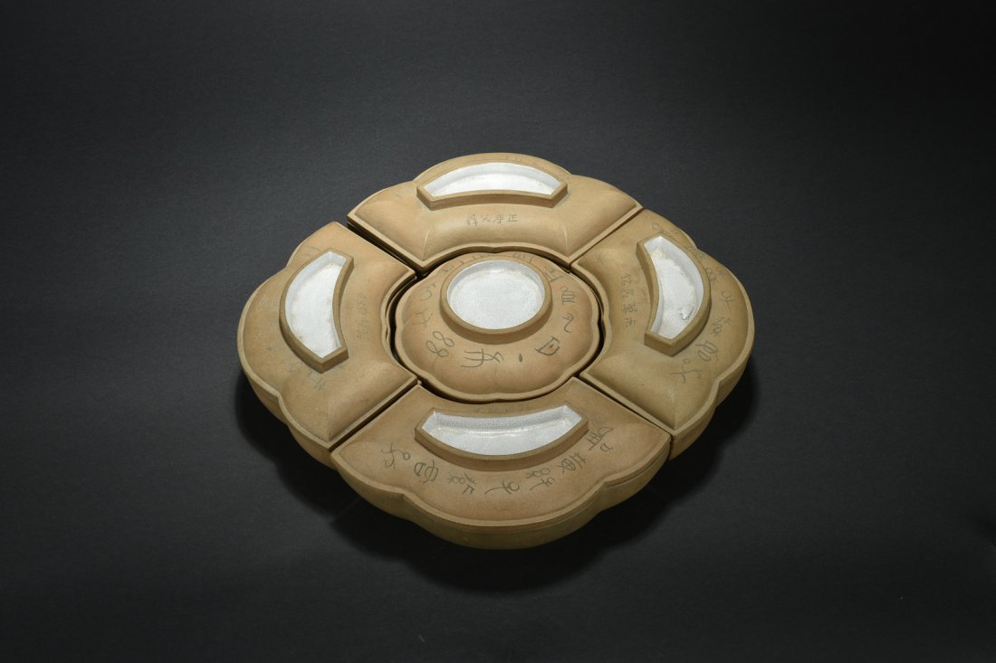 SET OF FIVE YIXING ZISHA CONTAINERS: The set includes a floriform center bowl with cover, and four surrounding covered containers, all with different calligraphy and incised landscape, the top, interior, and bottom glazed in white with c