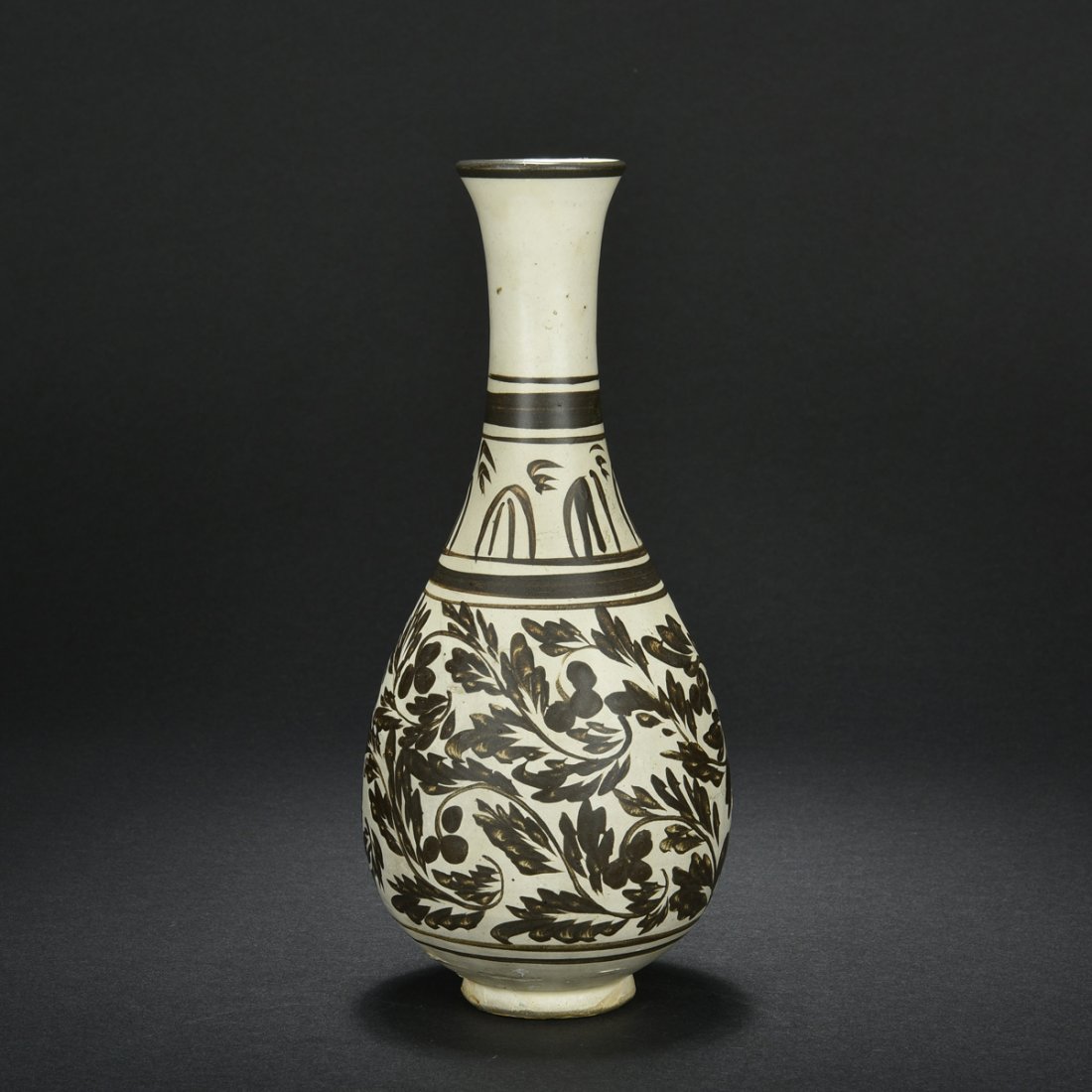 CIZHOU WARE FLOWER VASE: Of graceful and slender baluster form, the Cizhou ware vase painted with flowers and vines in brown against yellowish-brown ground, bottom unglazed. Jin Dynasty period. H: 9 3/4 in (24.8 cm) W: 4 1/4 