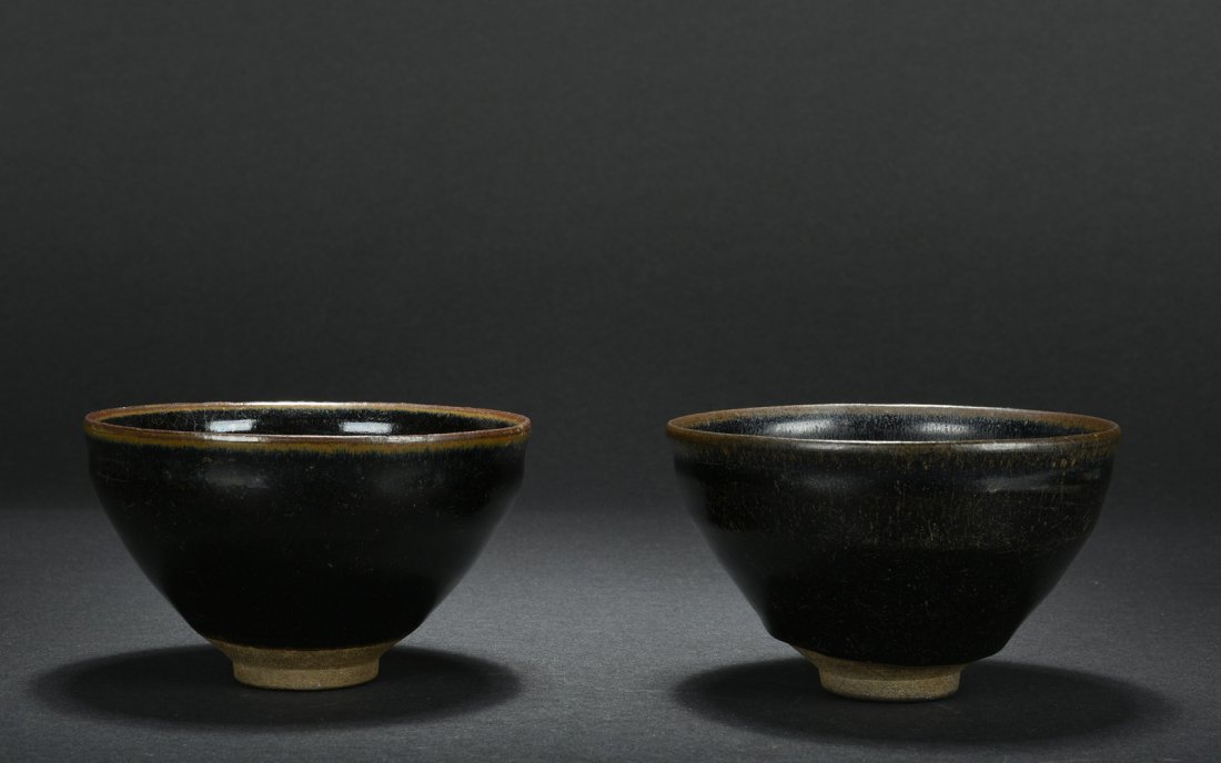 PAIR OF JIAN WARE BLACK GLAZED BOWLS: The Jian ware bowls glazed in black with thin hair patterns, brown glaze on top and unglazed on bottom. Song Dynasty period. H: 3 in (7.6 cm) D: 4 7/8 in (12.2 cm)