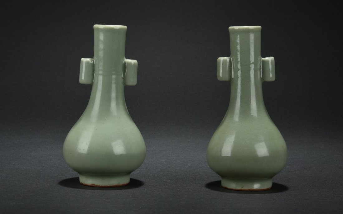 PAIR OF LONGQUAN WARE VASES: The pair of bottle vases have pear shaped body rising to long and straight neck, the sides with two lugnut handles, glazed overall in even celadon. Song Dynasty period. H: 6 1/4 in (15.8 cm) D: 2 1/4