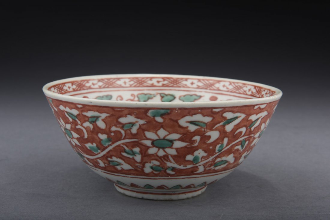 SANCAI GLAZED BOWL: The bowl glazed in sancai, depicting flowers and vines against red ground on the exterior, and a phoenix in the interior, bottom remain unglazed. Early Ming Dynasty period. D: 5 3/4 in (14.6 cm) H: 2 