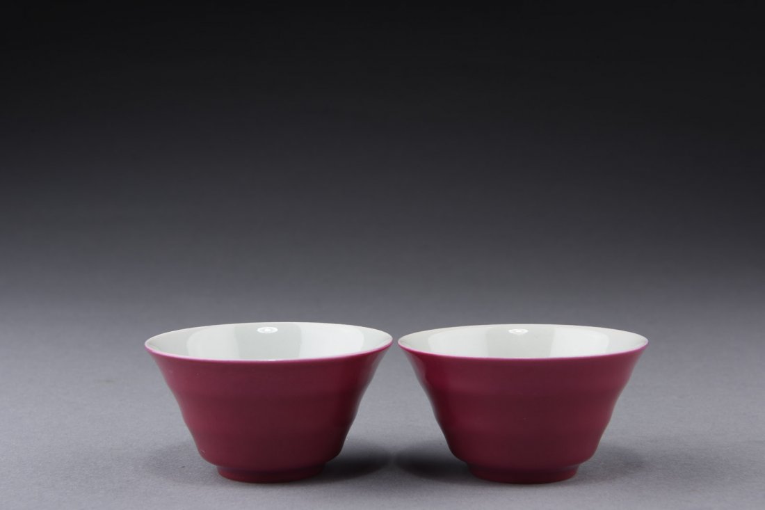 PAIR OF MONOCHROME RED GROUND CUPS: The cups' body with sectional ring 'Xuan' pattern, glazed on the exterior in monochrome red, the interior glazed white, and bottom bears six character 'YONGZHENG' mark. H: 1 1/2 in (3.7 cm) D: 2 7/8 i
