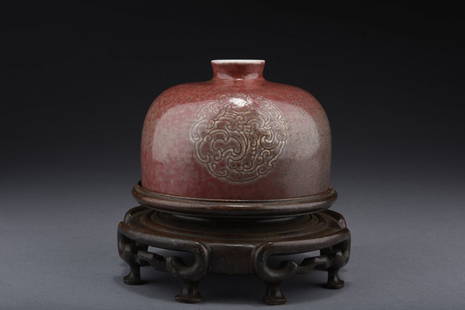 RED GLAZED 'DRAGON' VESSEL, ZUN: The domed formed vessel depicts dragons amidst clouds on the front and back, against red ground, on top of a well carved wooden stand, the bottom bears six character 'KANGXI' mark. Qing Dynasty period