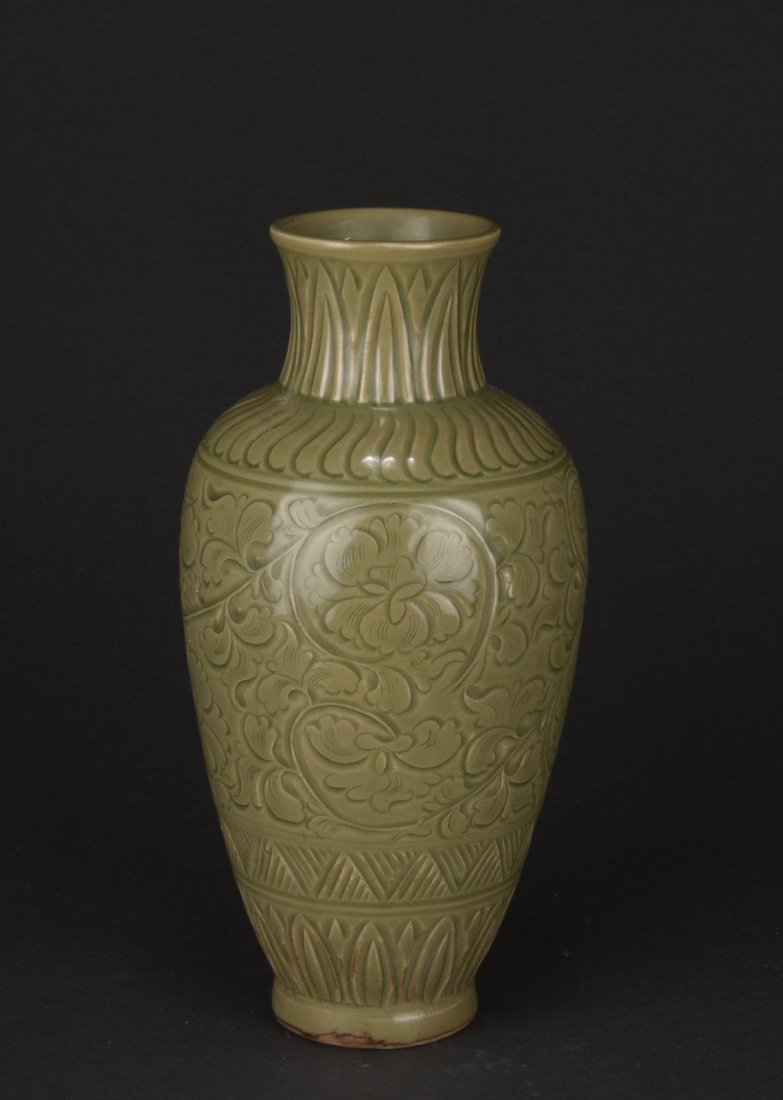 YAOZHOU WARE GREEN GLAZED 'FLOWERS' VASE: The olive shaped vase's body depicts flowers amidst leafy tendrils, in-between leaf patterns, the bottom unglazed, in the Song Dynasty style. H: 12 1/4 in (31.1 cm) D: 5 1/2 in (14 cm)