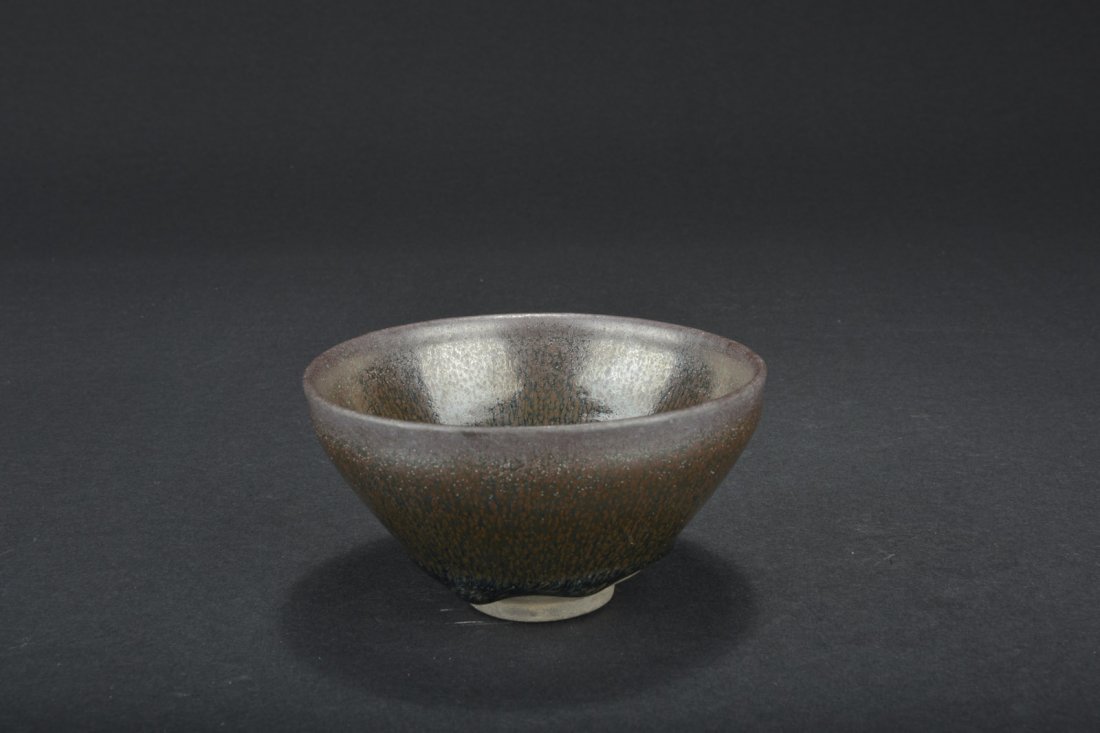 JIAN WARE 'OIL DRIP' BOWL: The Jian ware bowl glazed with oil drip patterns, with diffused brown and black, the bottom completely unglazed. D: 5 in (12.2 cm) H: 2 5/8 in (6.8 cm)