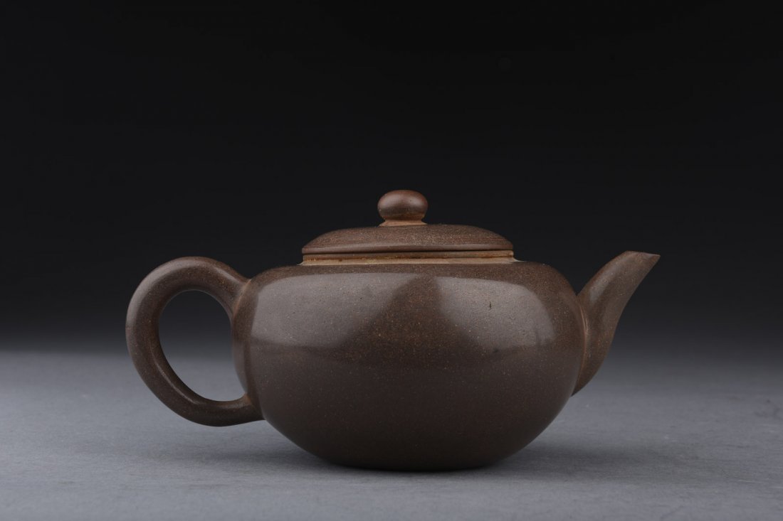 MENG CHEN: YIXING ZISHA POLISHED TEAPOT: Of slightly compressed globular form, the Yixing Zisha teapot polished on the exterior, with C shaped handle and upward-lifted spout and bead finial, bottom bears two character 'Meng Chen' mark. W: 6