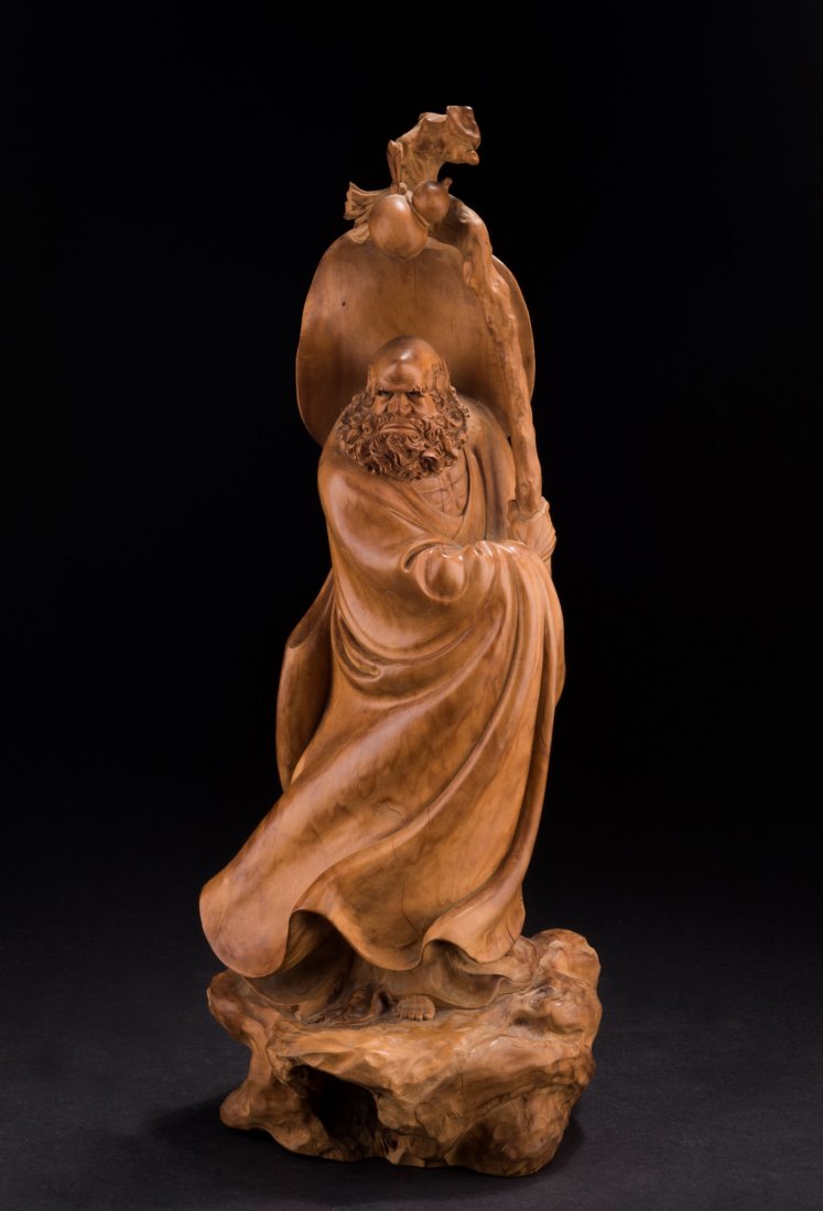 SANDAL WOOD CARVED BODHIDHARMA FIGURE: The carving depicts the Bodhidharma wearing long flowing robe, standing on top of rocky edge, holding a cane with double gourd hanging on top, with a large hat on the back, complete with stern express