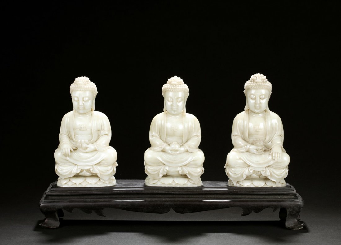 SET OF THREE SHOUSHAN SOAPSTONE TRIKAYA BUDDHA: The three Buddha all seated in dhyanasana on top of lotus thrones, wearing loose robe draped over shoulder, a swastika on the chest of each Buddha, pendulous earlobes, curled hair, and serene expressi