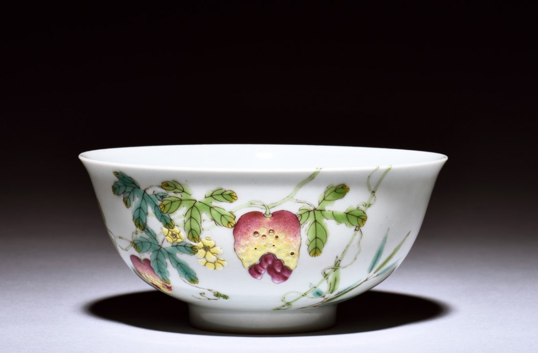 FAMILLE ROSE 'FLOWERS' BOWL: The famille rose bowl painted with flowers, guava, plants, and butterflies, the bottom bears six character QIANLONG mark. Height: 2 1/4 in (5.7 cm) Diameter: 4 7/8 in (12.4 cm)
