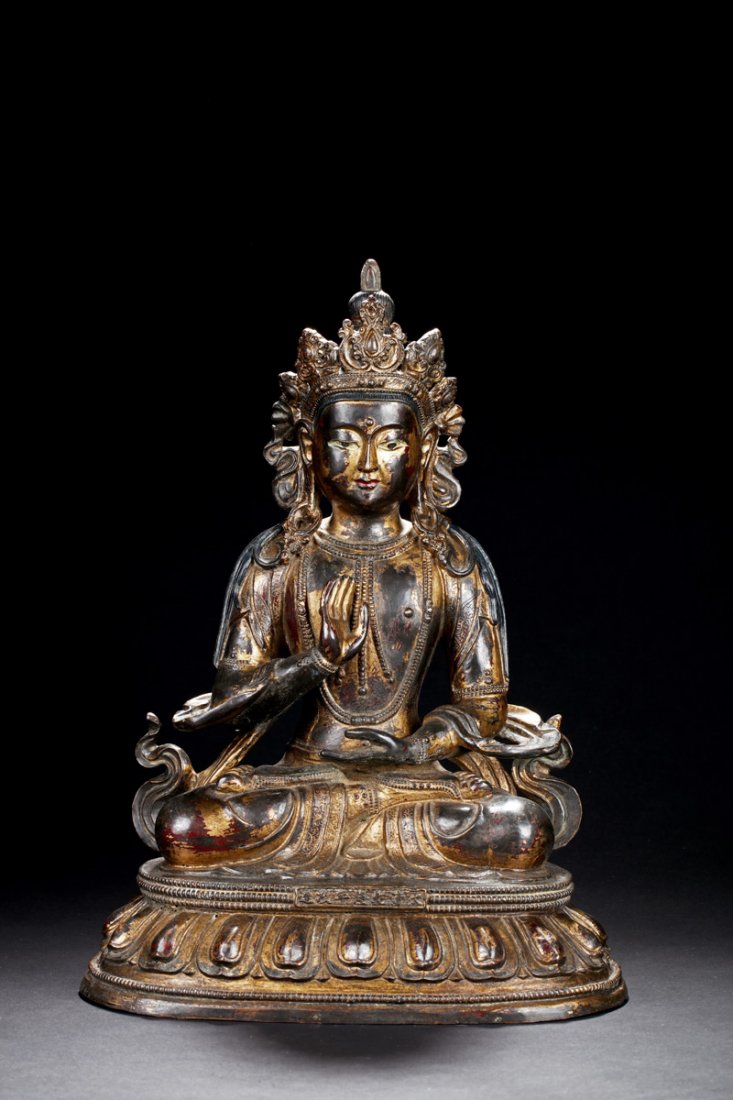 GILT BRONZE SEATED AVALOKITESHVARA FIGURE: The Avalokiteshvara seated on lotus throne pad in dhyanasana, one hands laying palm up on the lap and the other raised in praying form, wearing decorative beaded ornaments and crown, the eyes open wit