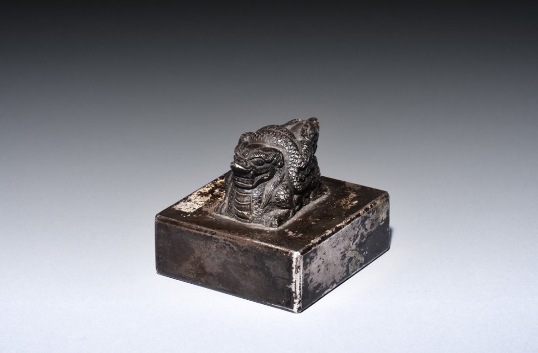 CARVED DRAGON STAMP SEAL: The stamp seal is of compressed square form, with a mythical dragon mounted on top, lying recumbent with twisting body, bottom of the seal bears six character mark. Height: 2 in (5.1 cm) Length: 2 1/4