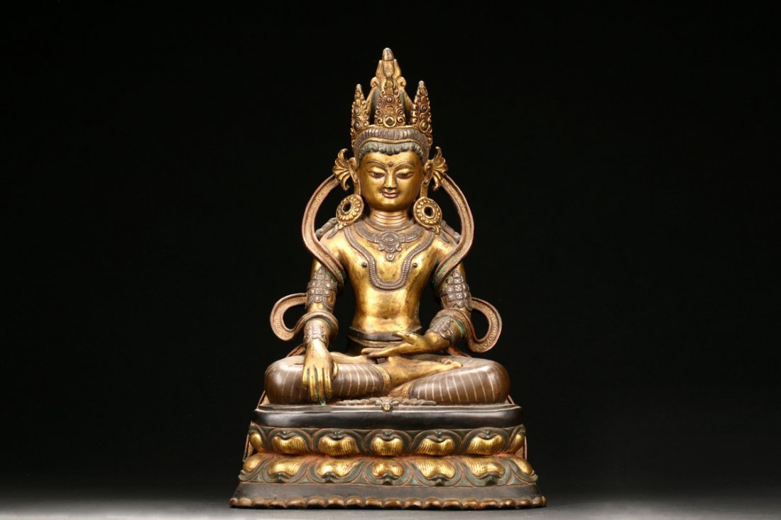 NEPAL GILT BRONZE SEATED AVALOKITESVARA: Seated on double lotus throne pad in dhyanasana, the Avalokitesvara hands in Bhumisparsa mudra, decorated with ornate necklace, sleeves, earrings, and crown, the eyes open in serene expression. 19/20t