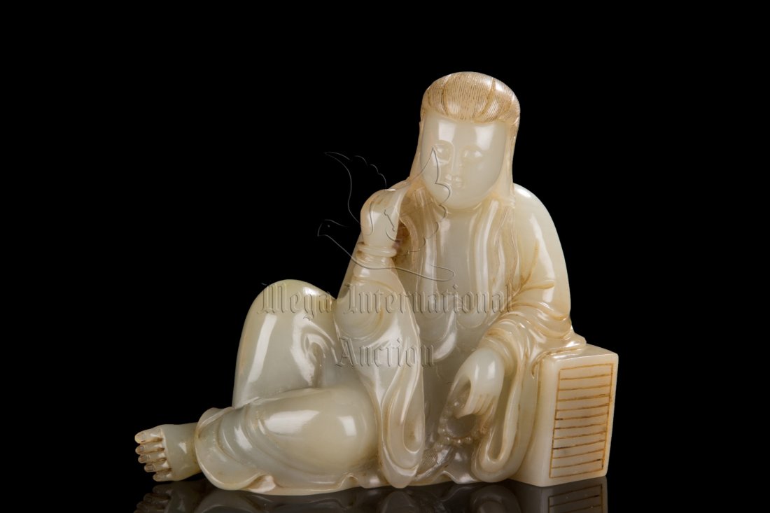 JADE CARVED SEATED GUANYIN: The carving depicts Guanyin seated on the ground, leaning on a stack of books, one hand holding prayer beads, the other wearing bangle and slightly raised, the long hair combed backwards and resting i