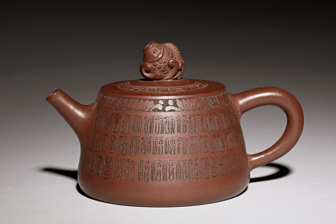 YIXING ZISHA 'HUNDRED SHOU' TEAPOT: Of expanding drum shape, the Yixing Zisha teapot incised with hundred different variations of Shou character on the body, with a carp shaped finial on top of flat lid, colophon and signature on the bo