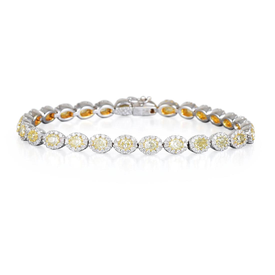 A White and Yellow Diamond Tennis Bracelet: Featuring 28 oval-cut yellow diamonds, weighing a total of approximately 3.14 carats, surrounded by small round-cut diamonds, weighing a total of approximately 1.71 carats, mounted in 18K white and ye
