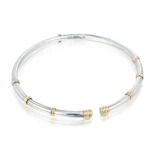 Ilias Lalaounis Silver and Yellow Gold Bamboo Collar: Designed as a torque collar, in brightly polished sterling silver with 18K yellow gold rings and terminal ends, hinged at back; measures 16 inches circumference, width 1/4 inch; weight 61.9 g. Stamped