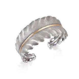 Mario Buccellati Leaf Cuff: Crafted out of silver, with a rose gold stem; the top side surfaces hand textured and shaped in the design of a curled leaf; inner circumference measures 7 inches, 1 inch wrist clearance, width 1-1/8