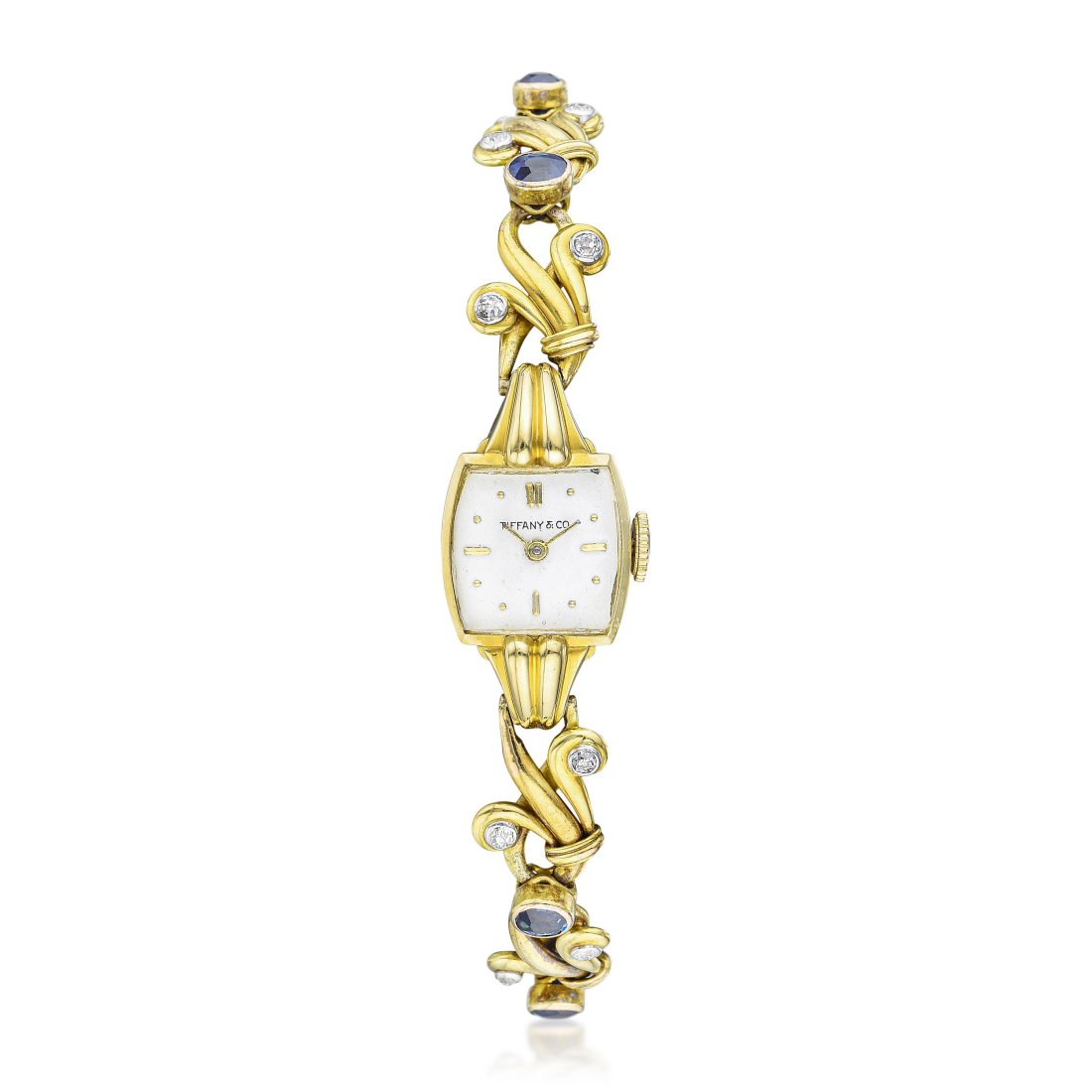 Tiffany & Co. Movado Ladies Watch in 18K Gold: CIRCA: 1950s CASE NUMBER: 0066812 REF.: 44246 CASE MATERIAL: 18K gold CASE DIMENSIONS: 16 mm wide x 29.5 mm lug-to-lug DIAL: White dial with applied hour markers BRACELET MATERIAL: 18K gold with diamo