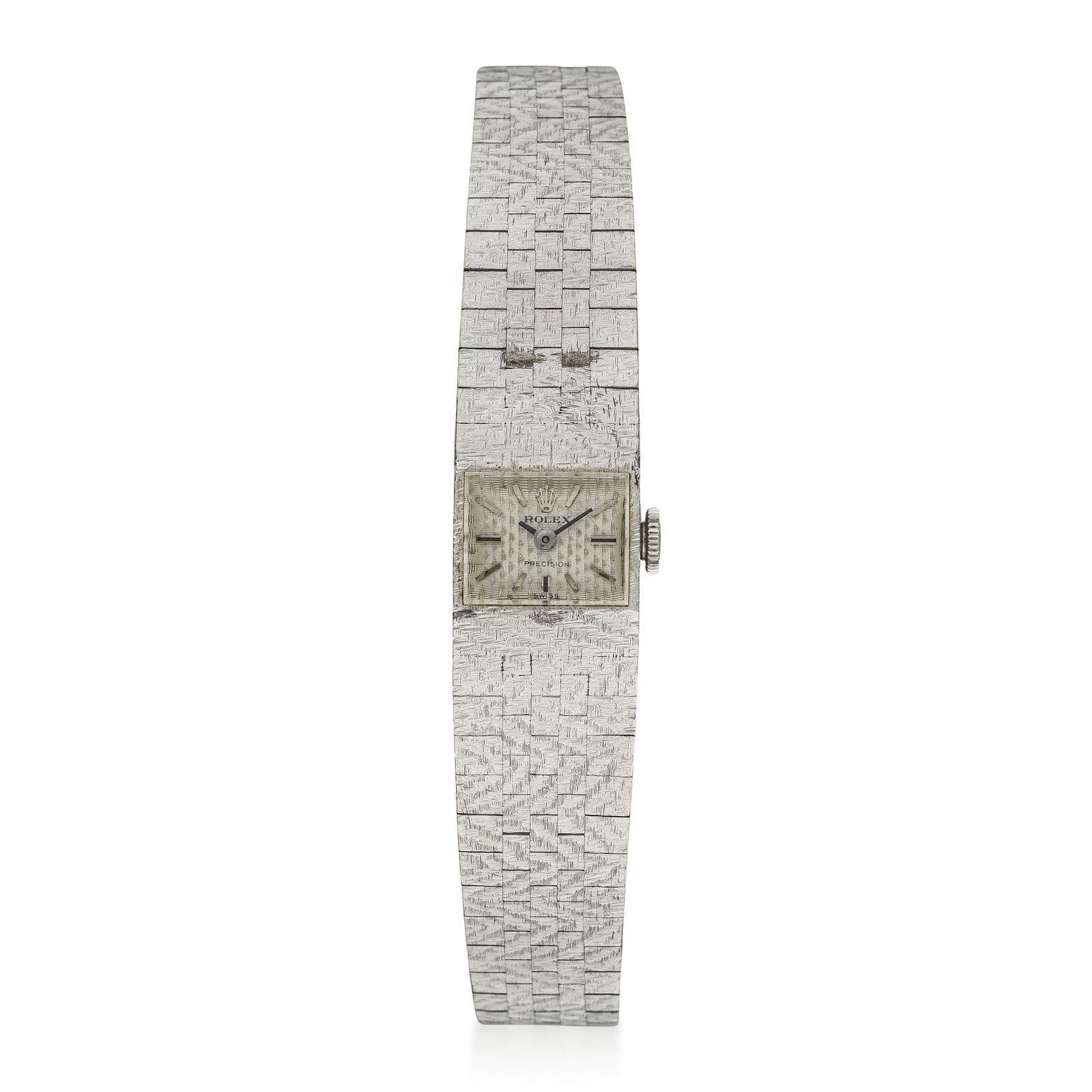 Rolex Ladies' Precision in 18K White Gold and Sterling Silver: Summary of Key Characteristics CIRCA: 1969 CASE MATERIAL: 18K white gold DIAL: Florentine-textured silver dial with applied hour markers BRACELET MATERIAL: Period aftermarket bracelet in sterling