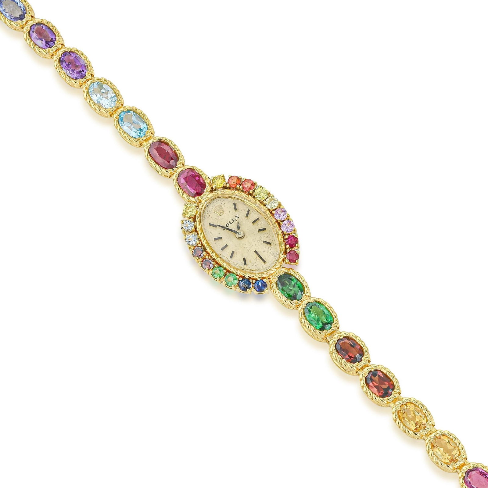 Rolex Ladies' Watch in 14K Gold: Summary of Key Characteristics CIRCA: 1960s CASE MATERIAL: 14K yellow gold with colored stones DIAL: Champagne dial with applied hour markers BRACELET MATERIAL: Rope style bracelet with colored