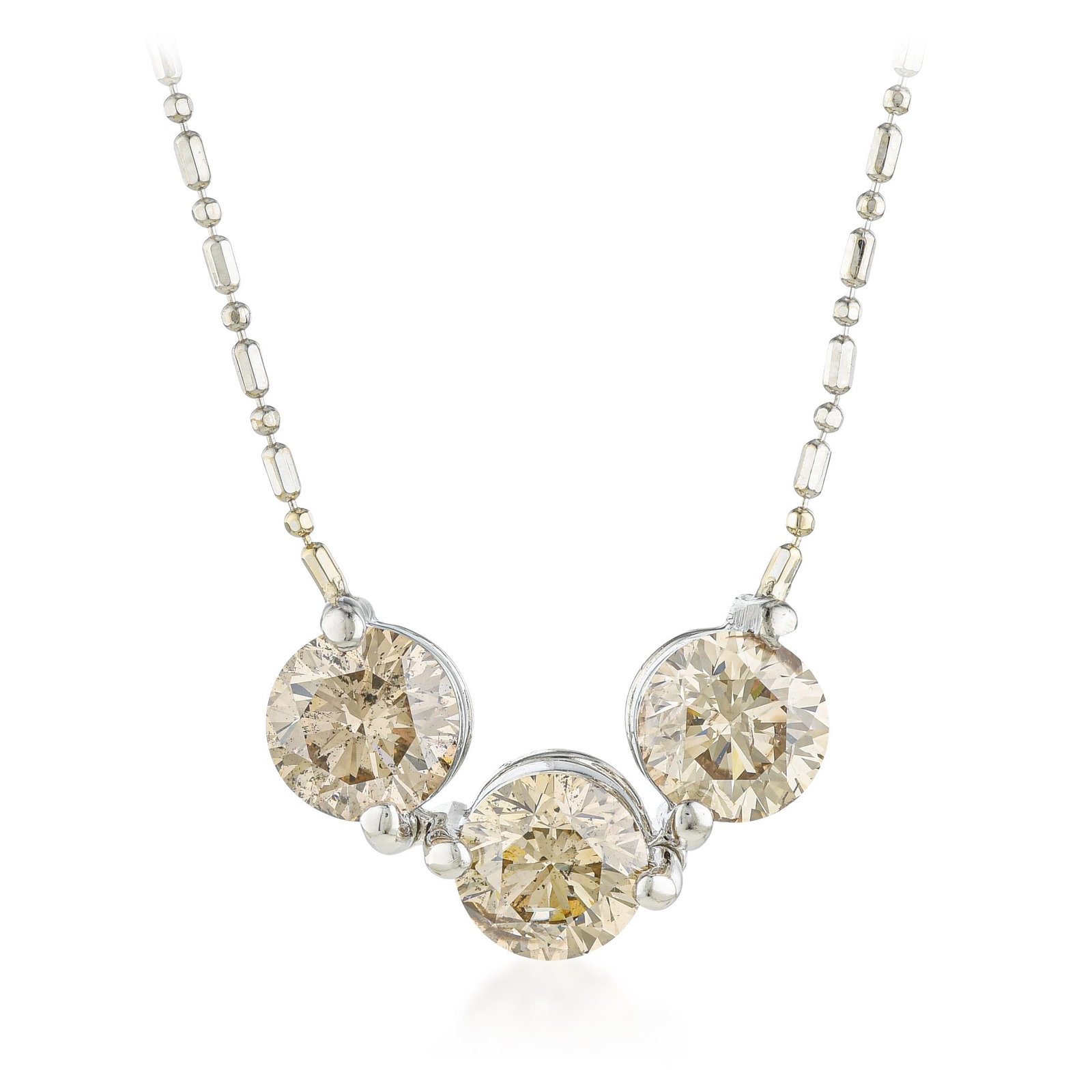Three Diamond Pendant Necklace: ESTIMATED RETAIL PRICE: $4,500* *This is the estimated value a piece of similar quality, craftsmanship, and characteristics could command at retail. Light brown diamonds — champagne, in the