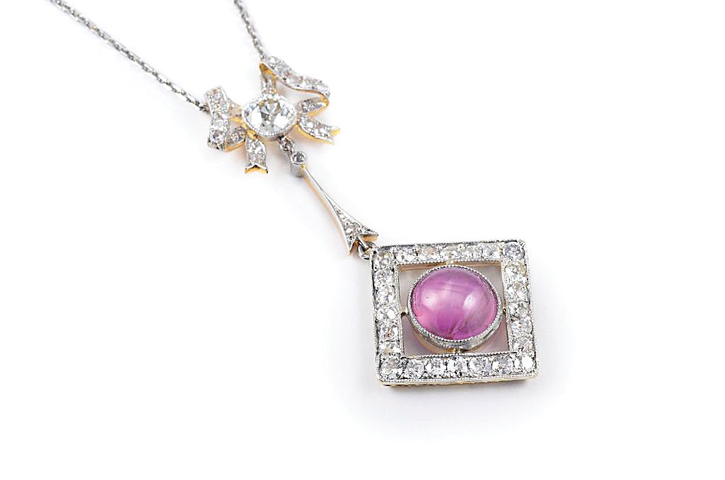 An Edwardian Platinum Diamond Star Ruby Necklace: Set with a central cabochon star ruby, weighing approximately 7 carats, one antique cushion-cut diamond, weighing approximately 1.30 carats, and numerous additional old-cut diamonds, weighing approxim