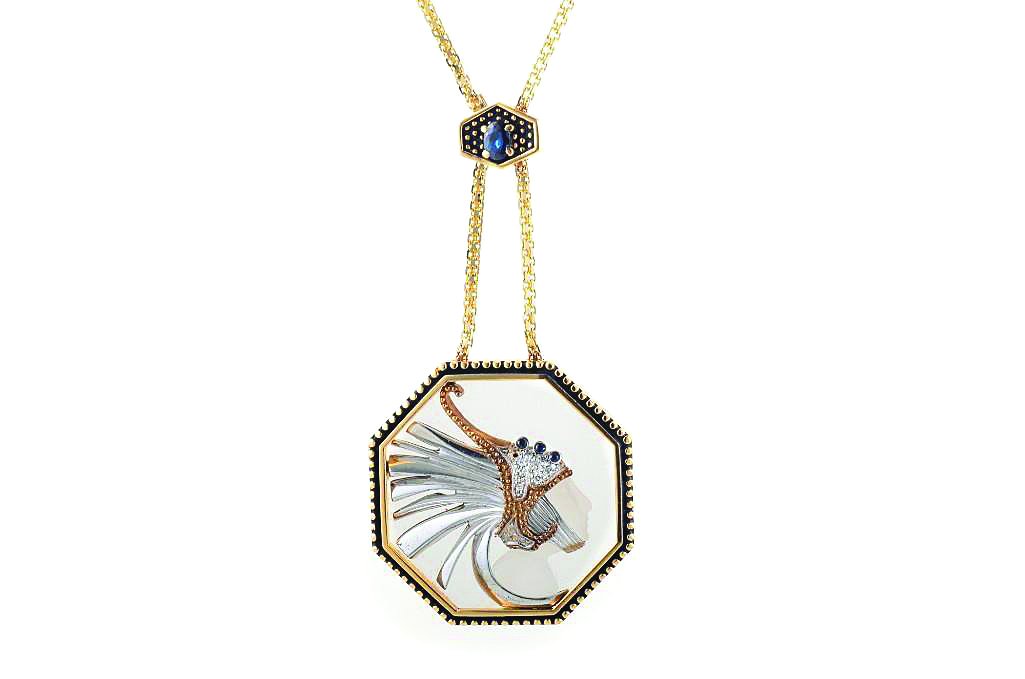 A Pendant Chain, by Erte: Frosted rock crystal octagonal pendant on a 14K yellow gold chain. Figure on the pendant is embellished with melee diamonds and stainless steel. Clasp is set with a central sapphire weighing approx 0.