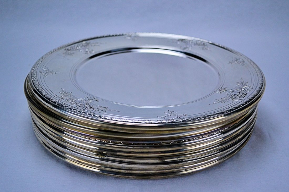 Meriden Brittania Sterling Silver Chargers (Set of 12): This is a wonderful set of twelve sterling silver dinner plates made by the Meriden Brittania Company, in Meriden, Connecticut. The plates have a large rim, outlined with delicate strapwork of an eleg