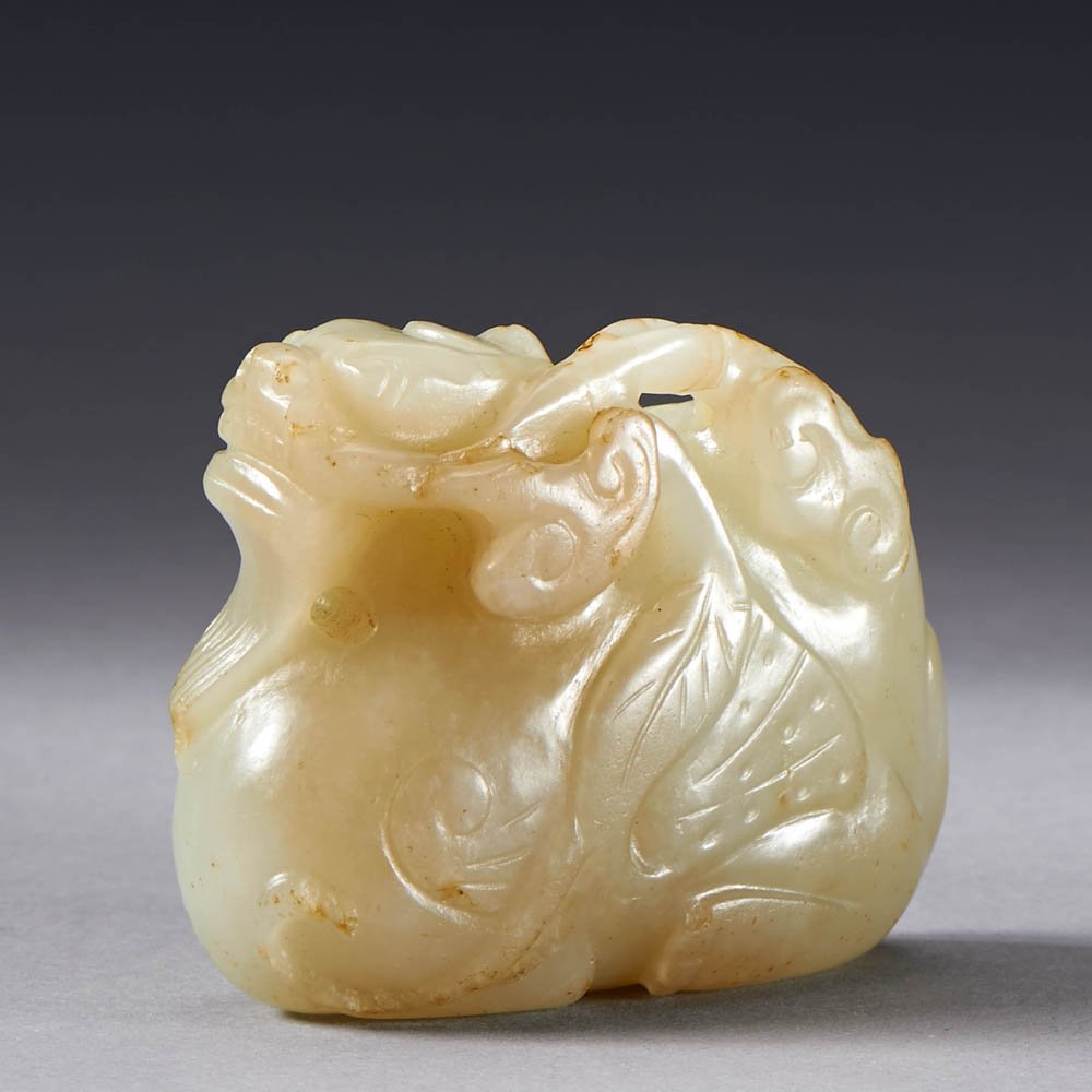A CHINESE WHITE JADE CARVING: MING DYNASTY (1368-1644) A CHINESE WHITE JADE CARVING OF 'MYTHICAL BEAST HOLDING LINGZHI' 明 白玉「瑞獸啣靈芝」 L 5.1 cm. (2 in.)