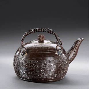 A CHINESE COCONUT SHELL 'ANBAXIAN' TEAPOT: 1950s A COCONUT SHELL 'ANBAXIAN' TEAPOT 'FENG BAI JU JING ZENG,OCT 1950, DONG FU ZONG LI HUI CUN' MARK H 17 cm. (6 5/8 in.) 1950年代 椰殼雕暗八仙茶