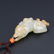 A CHINESE WHITE AND RUSSET JADE DOG PENDANT