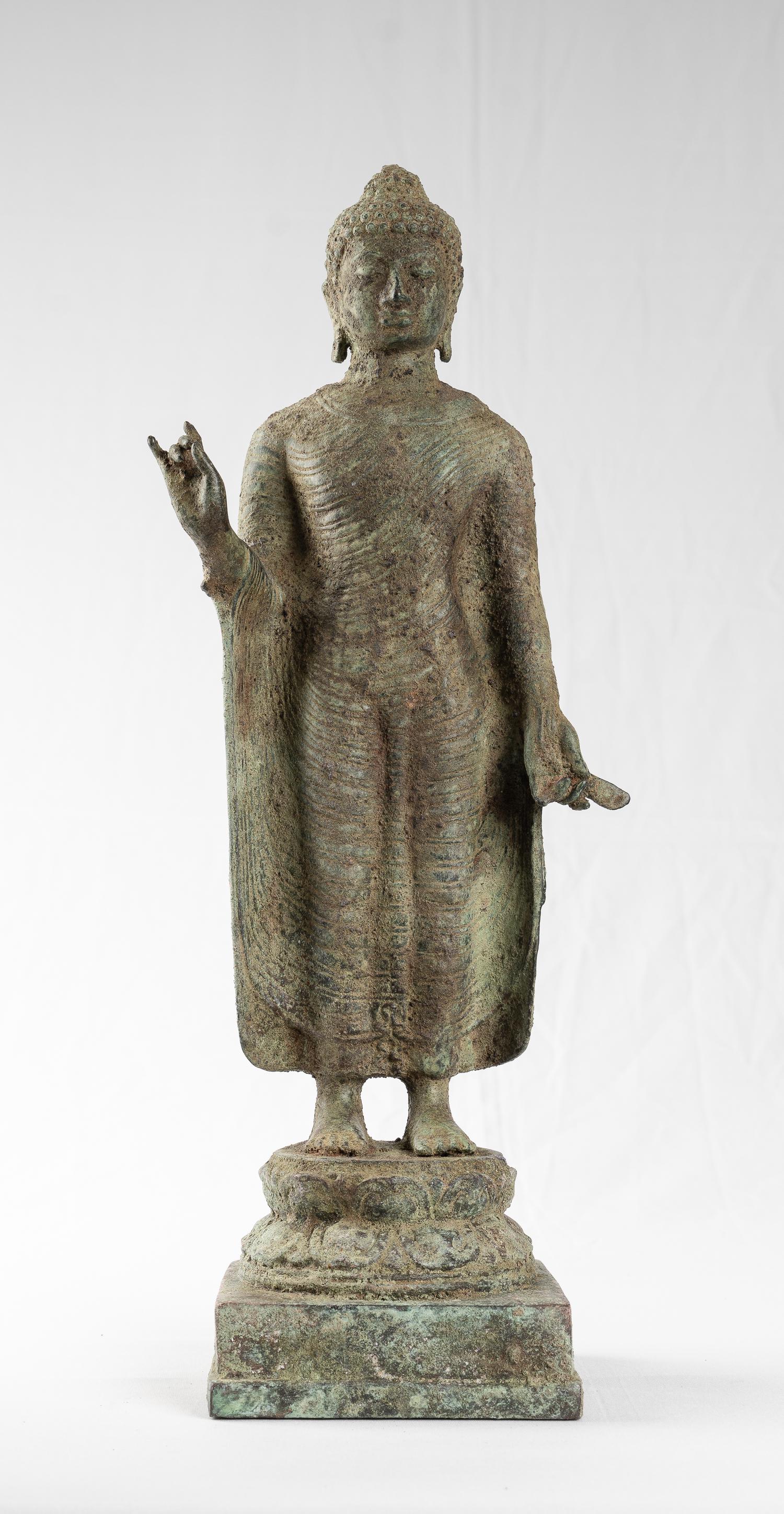 Antique Indonesian Style Bronze Standing Java Teaching: An Indonesian (Java) Teaching Buddha in 13th century Majapahit style. This lovely Buddha is stood samabhanga on a circular double-lotus pedestal, itself on a square pedestal. His robe is draped over b