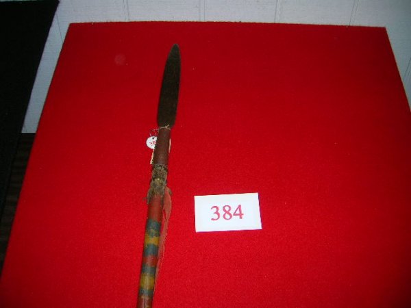 384: Crow War Lance: Crow War Lance, hand forged blade style head with tang, original wooden haft features red, yellow, and blue paint, rawhide fringed wrap and brass tack decoration, 67", museium quality. This could poss