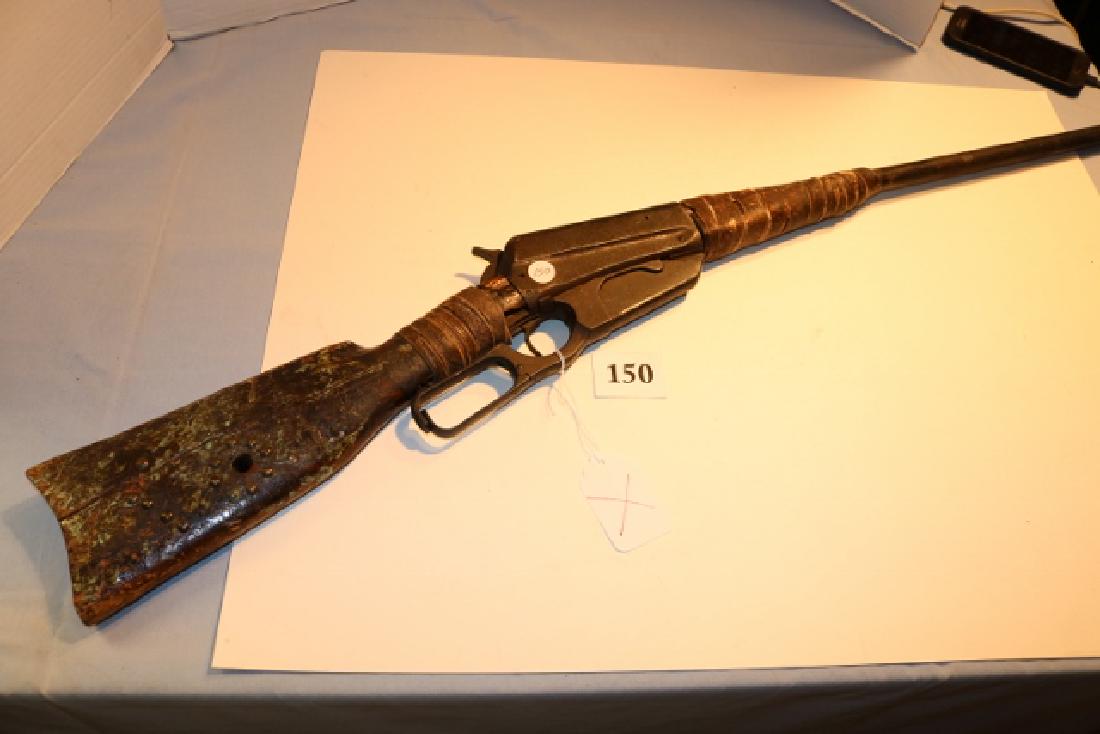 1895 Winchester Indian Modified Rifle: 1895 Winchester Indian Modified Rifle, rawhide wrapped forearm and wrist, pierced hole in butt stock, brass tacking decoration, traces of heavy paint, will not cock