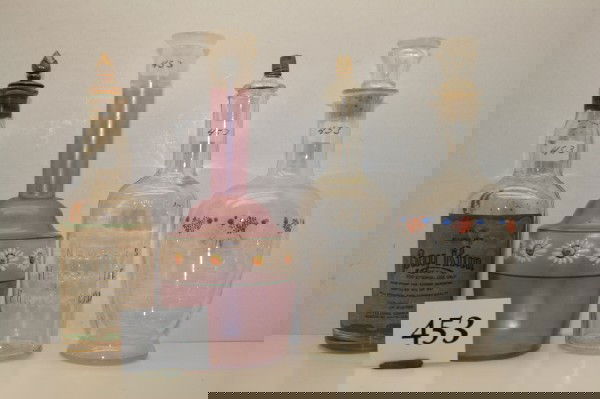 4 Clear Glass Barber Bottles: 4 Clear Glass Barber Bottles – clear with amethyst wash with enameled flowers & Bay Rum with flame stopper & Newbro's & Hand Blown with blue & orange enamel