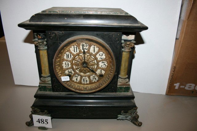 Seth Thomas Mantel Clock: Seth Thomas Mantel Clock – 2 celluloid pillars on front, wood marbleized case – brass lions heads on side with brass ormolu feet – has key & pendulum but does not run – missing pieces on top o