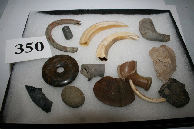 13 pieces Village Site Material: 6 x 8 Frame containing 13 pieces Village Site Material – such as clay pipe, bead, 3 beaver teeth, broken clay pipe, pottery fragments