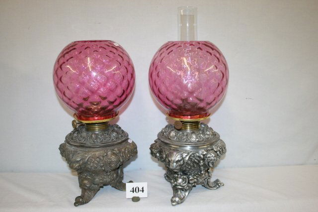 Pair Griffin & Cherub Kerosene Lamps: Pair of Cast Griffin & Cherub Kerosene Lamps with cranberry rep. shades & fitters
