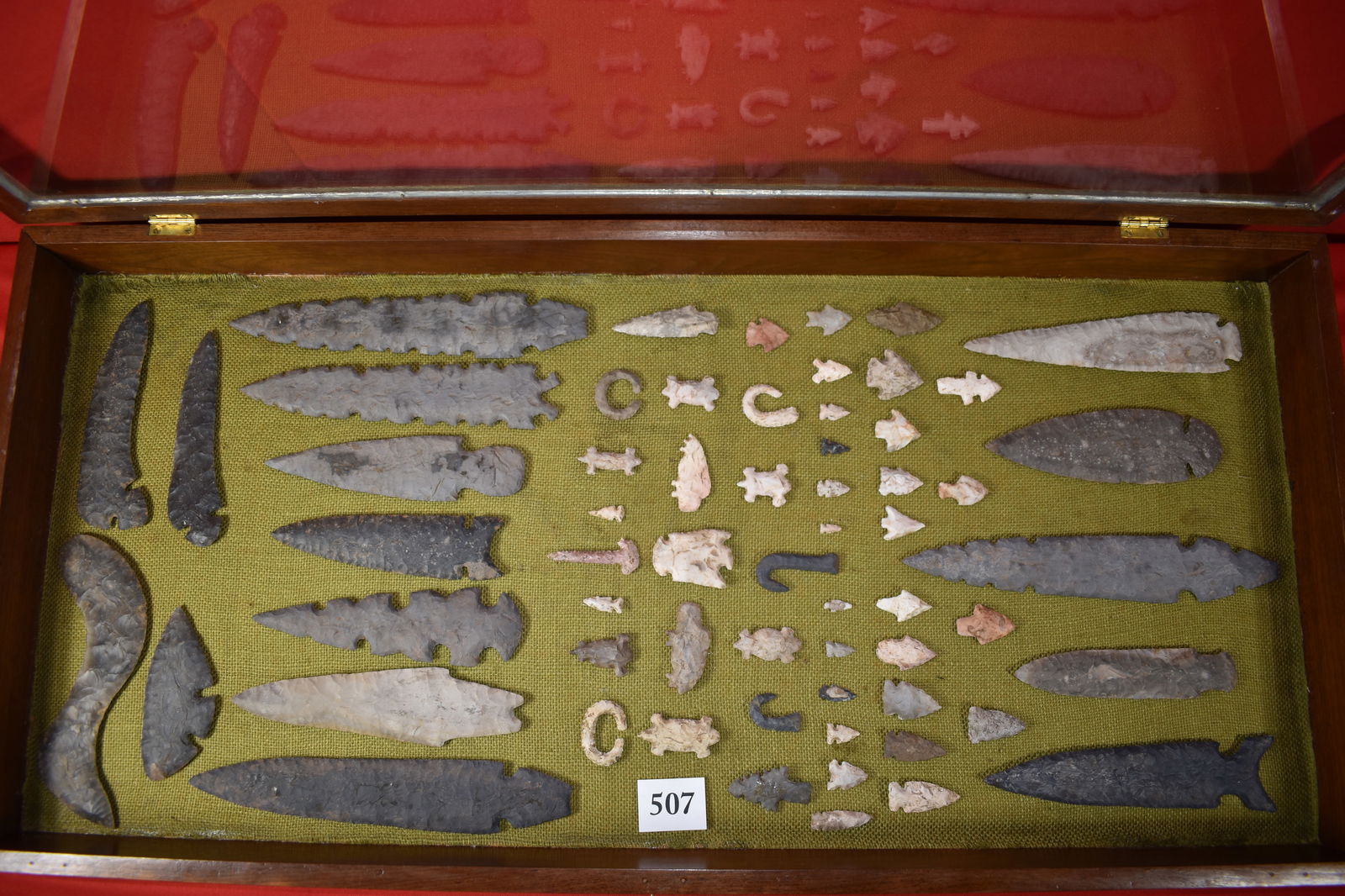Custom Wood Frame with over 65 display: Custom Wood Frame with over 65 display pieces glued in, includes flint spears & boomerang, fetishes, hooks etc… great looking display 12” will not ship