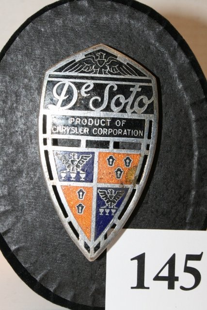 DeSoto enameled auto emblem: DeSoto enameled auto emblem on display stand, 2” x 3 ½”