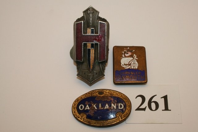 Three enameled auto emblems: Three enameled auto emblems: Hudson, Oakland (missing enamel), Chrysler Plymouth ( missing enamel)