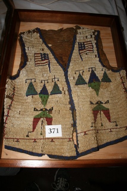 Beaded Sioux Patriotic Man’s Vest: 21” x 18” Beaded Sioux Patriotic Man’s Vest – fully beaded, with American Flags, heavily stained some beadwork missing, some stiffness, has bullet hole, possibly found at Wounded Knee Massacre