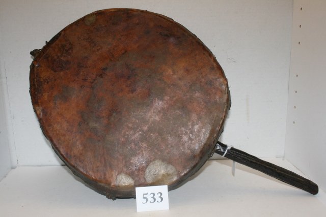 Round Hide Covered Drum/Rattle: 14 ½” x 3 ¼” Round Hide Covered Drum/Rattle with 7 ½” Wood Handle, several early repairs – circa 1890 – nice old original artifact