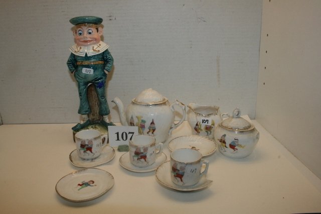 11 Pc. Tea Set - Palmer Cox Brownie: 11 Pc. Tea Set with Palmer Cox Brownie Scene – 1 cup & creamer – broken & cracked -2 Cups are Ok plus 8 ¾” Majolica Sailor which has been broken & reglued by feet – chunk missing on leg 5 sau